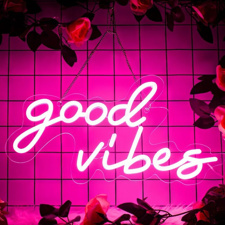 Néon Good Vibes rose allumé sur un mur